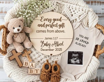 May include: A baby announcement display in a wicker basket. It features a wooden sign with text, a teddy bear, a cross, baby booties, and a onesie with an ultrasound image. The sign reads "Every good and perfect gift comes from above."