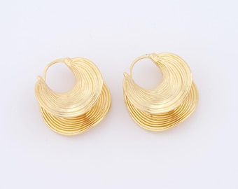 May include: A pair of gold-colored earrings. Each earring features a layered, crescent-shaped design with a ridged texture. The earrings have a simple hook closure and are set against a white background.