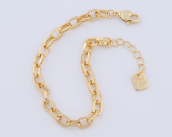 May include: Gold-colored chain bracelet with textured oval links. The bracelet has a lobster clasp closure and an adjustable chain with a small rectangular charm that reads "Good Luck".