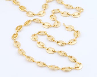 May include: A gold-colored chain necklace with a series of oval-shaped links. The links are connected by small, delicate connectors. The necklace is displayed on a white background, highlighting its shiny, reflective surface. The chain is a stylish accessory.