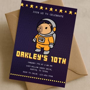 May include: A birthday party invitation featuring a cartoon capybara astronaut on a dark blue background. The invitation includes the text "JOIN US TO CELEBRATE" and "OAKLEY'S 10TH", along with event details and RSVP information.