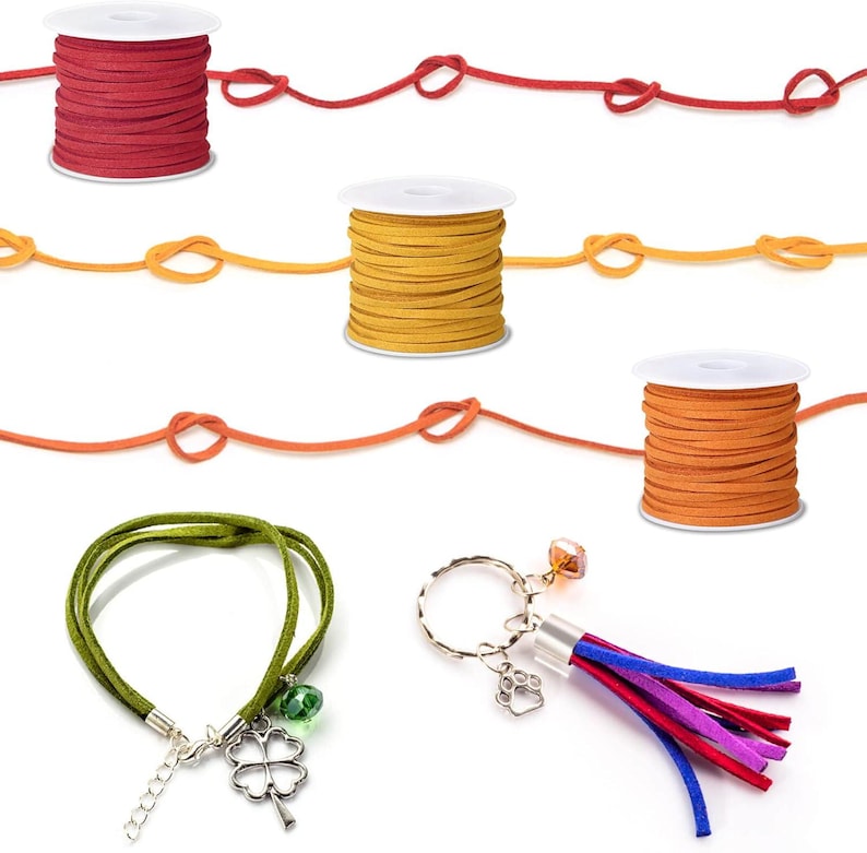 May include: An assortment of craft supplies including spools of red, yellow, and orange suede cord, a green suede bracelet with a four-leaf clover charm, and a keychain with a paw print charm and colorful tassel.