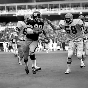 Pittsburgh Steeler Lynn Swann moves after catching a pass from Terry Bradshaw during December 1974 game at Pittsburgh three rivers stadium.