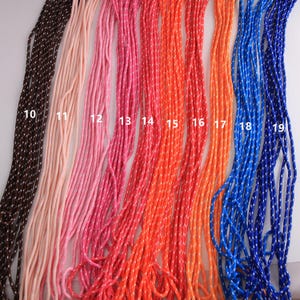 May include: A collection of colorful cords in various shades, including brown, pink, red, orange, and blue. Each cord is a different color and has a white dotted pattern. The cords are arranged vertically, showcasing a range of hues.
