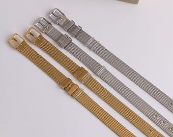 May include: Four metal mesh watch bands in gold and silver. The bands have a fine mesh design and feature adjustable clasps and holes for sizing. The gold bands have a warm, shiny finish, while the silver bands have a cool, metallic appearance.