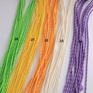 May include: A collection of colorful cords in shades of green, yellow, orange, cream, and purple. The cords are numbered 20 through 24. The yellow, orange, and purple cords have a white dotted pattern.