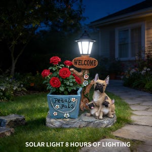 Könnte beinhalten: Dekorative Solar-Außenleuchte mit einem Pflanzgefäß mit roten Rosen, einem "Welcome"-Schild und einer Skulptur eines französischen Bulldoggen mit Welpen. Auf dem Pflanzgefäß steht "Petal Pals". Die Lampe leuchtet.