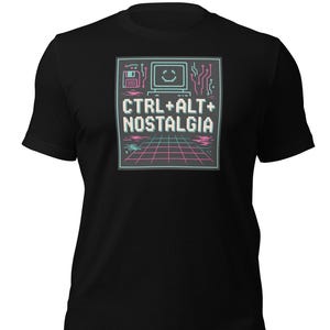 May include: Black t-shirt with a retro computer graphic. The design features a pixelated computer, a floppy disk, and the text "CTRL+ALT+NOSTALGIA" in white. The graphic uses neon pink and teal colours.