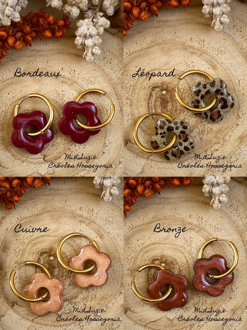 May include: Four pairs of flower-shaped earrings with gold hoops. The earrings come in four colors: burgundy, leopard print, copper, and bronze. The text "Bordeaux", "L&eacute;opard", "Cuivre", and "Bronze" are written above each pair of earrings. The text "Mid Suzie Cr&eacute;oles Hossegoria" is written below each pair.