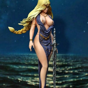 May include: A figurine of a woman with long blonde hair, wearing a dark blue dress with gold accents and holding a silver sword. The figure is posed against a backdrop of a starry night sky and ocean.