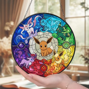 May include: A round stained glass window featuring various Pokémon characters in a colorful design. The window has a black border and is suspended by a chain. The central character is Eevee, surrounded by other Pokémon in a vibrant, artistic style.