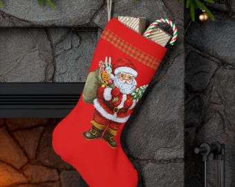 Puede incluir: Un calcetín navideño rojo con una ilustración de Papá Noel, lleno de regalos y un bastón de caramelo. El calcetín cuelga de una chimenea de piedra, decorada con guirnaldas y adornos.