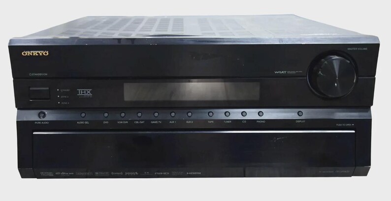 May include: A black Onkyo audio-video receiver featuring a large volume knob on the right, a central digital display, and a row of input selection buttons. The front panel displays the Onkyo logo, THX certification, and WRAT technology branding.