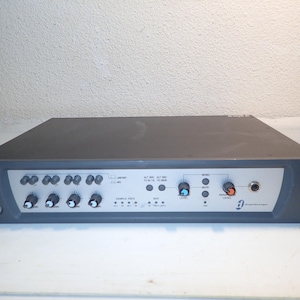 May include: A dark gray Digidesign 002 Rack audio interface featuring a front panel with multiple rotary knobs, push buttons, LED indicators, a headphone jack, and the text Digidesign 002 Rack printed on the right side of the metal chassis.