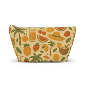Può includere: Una pochette con cerniera caratterizzata da un motivo ripetuto di elementi tropicali su sfondo marrone chiaro. Il design include palme, cappelli di paglia, infradito, ananas, fragole, ciliegie, fette di anguria, arance e bevande al cocco.