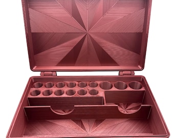 May include: Open, red-brown toolbox with an organized interior. The case is rectangular with a hinged lid and a latch closure. Inside, there are various compartments and cylindrical holders for tools or small items. The interior features a geometric starburst design.