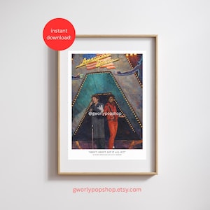 May include: Framed print featuring a stage scene with two figures in front of a teal backdrop. The print includes the text "American Dream" and "Shout, Shout, Let It All Out". The image is in a wooden frame.