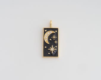 May include: Gold-tone pendant with a black enamel background featuring a crescent moon with clear crystals and star designs. The rectangular pendant has a gold bail for hanging. A celestial-themed jewelry piece.