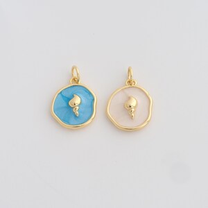 Peut inclure: Deux pendentifs dorés avec un motif de torche. L'un a un fond en émail bleu clair, l'autre rose pâle. Les deux ont une torche dorée au centre et un bord doré.