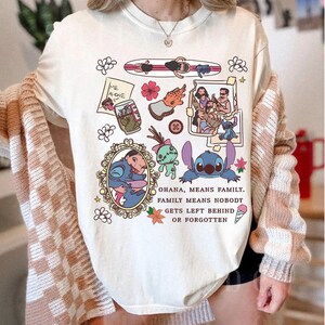 Peut inclure: T-shirt cr&egrave;me avec des illustrations de personnages et de sc&egrave;nes de dessins anim&eacute;s. Le t-shirt comprend le texte "OHANA, MEANS FAMILY. FAMILY MEANS NOBODY GETS LEFT BEHIND OR FORGOTTEN."