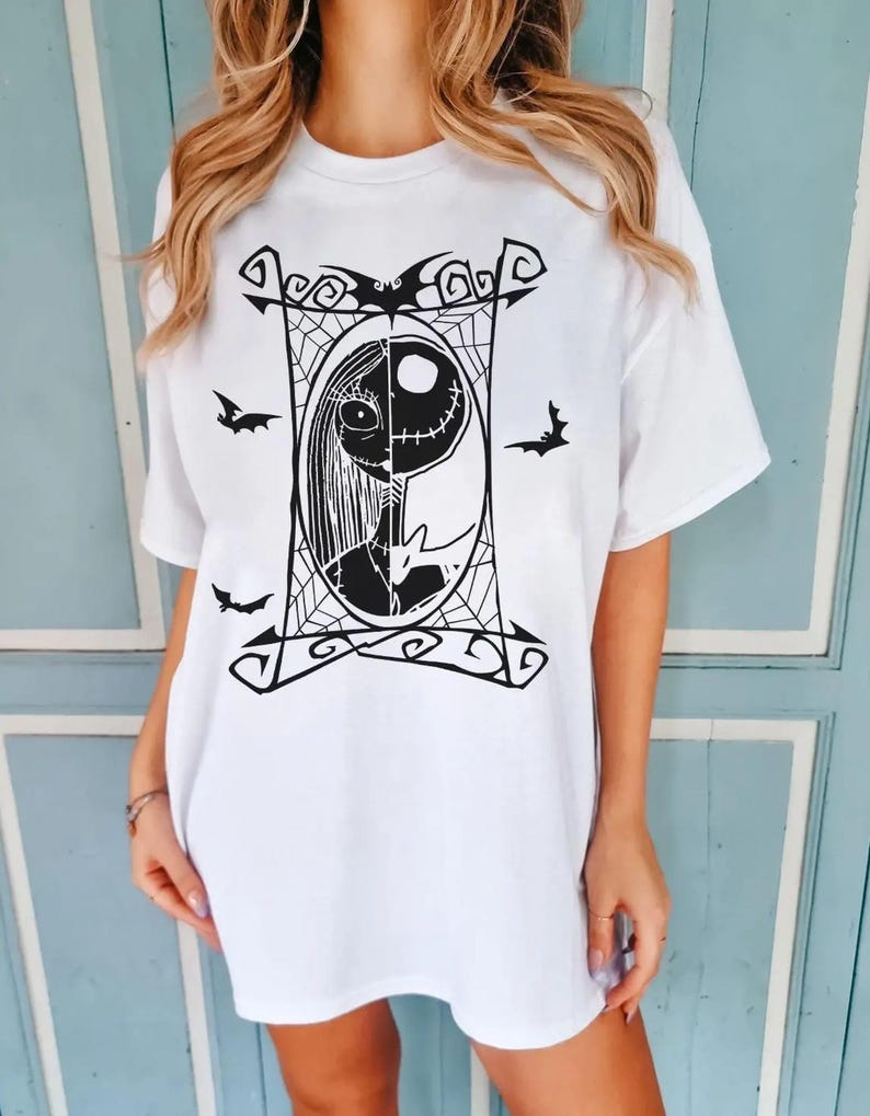 May include: White t-shirt featuring a black and white graphic of Jack Skellington and Sally from The Nightmare Before Christmas. The design is framed by a decorative border with bats and spiderwebs.