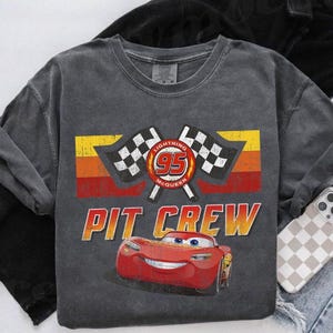 May include: A white ceramic mug with a black handle and the text "But First, Coffee" in a bold, black font. The mug is set against a neutral background, highlighting its simple design.