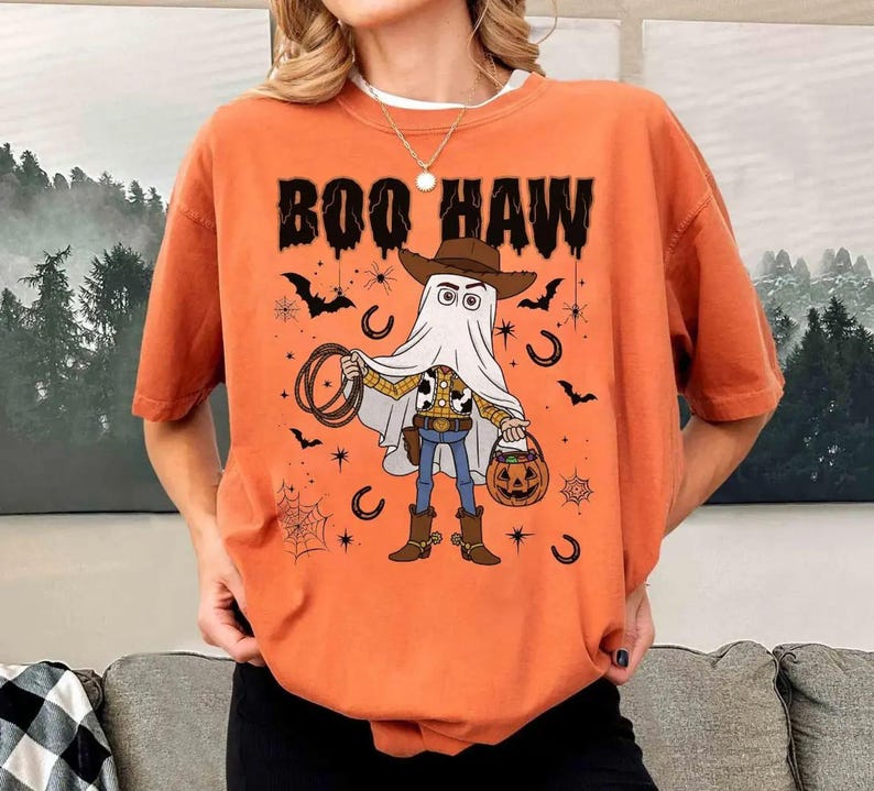 May include: A white ceramic mug with a black handle and the text "But First, Coffee" in a bold, black font. The mug is set against a blurred background, suggesting a cosy setting.