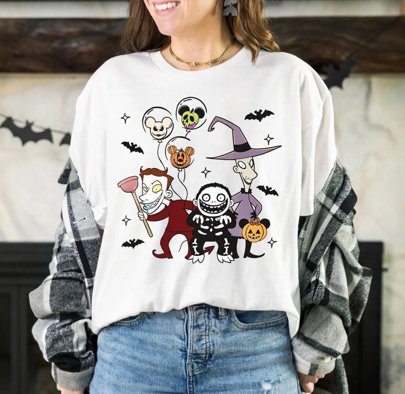 May include: White t-shirt with a colourful graphic of characters from The Nightmare Before Christmas. The design includes Jack Skellington, Sally, and other Halloween Town residents, along with bats and balloons. A fun, festive design for fans of the movie.