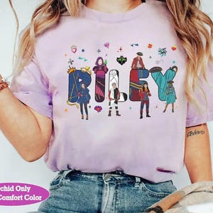 May include: Pale lilac t-shirt featuring the name "Riley" in vibrant, illustrated letters. Each letter incorporates a character design. The shirt also has the text "Orchid Only With Comfort Color" at the bottom.