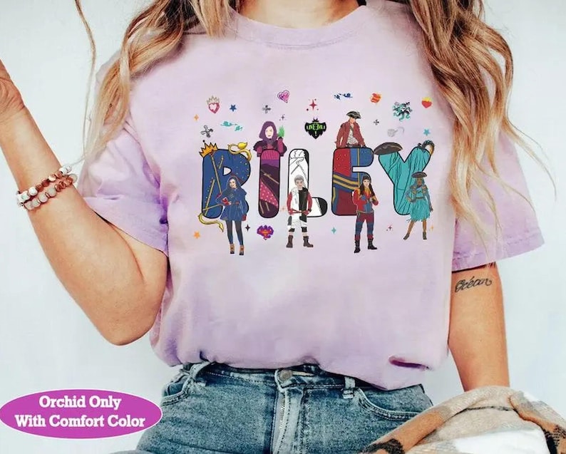 May include: Pale lilac t-shirt featuring the name "Riley" in vibrant, illustrated letters. Each letter incorporates a character design. The shirt also has the text "Orchid Only With Comfort Color" at the bottom.