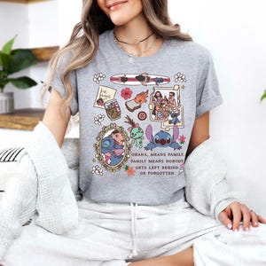 Peut inclure: T-shirt gris chin&eacute; avec un motif graphique color&eacute;. Le motif comprend un personnage de dessin anim&eacute; et d'autres images connexes, avec le texte "Ohana, means family. Family means nobody gets left behind or forgotten."