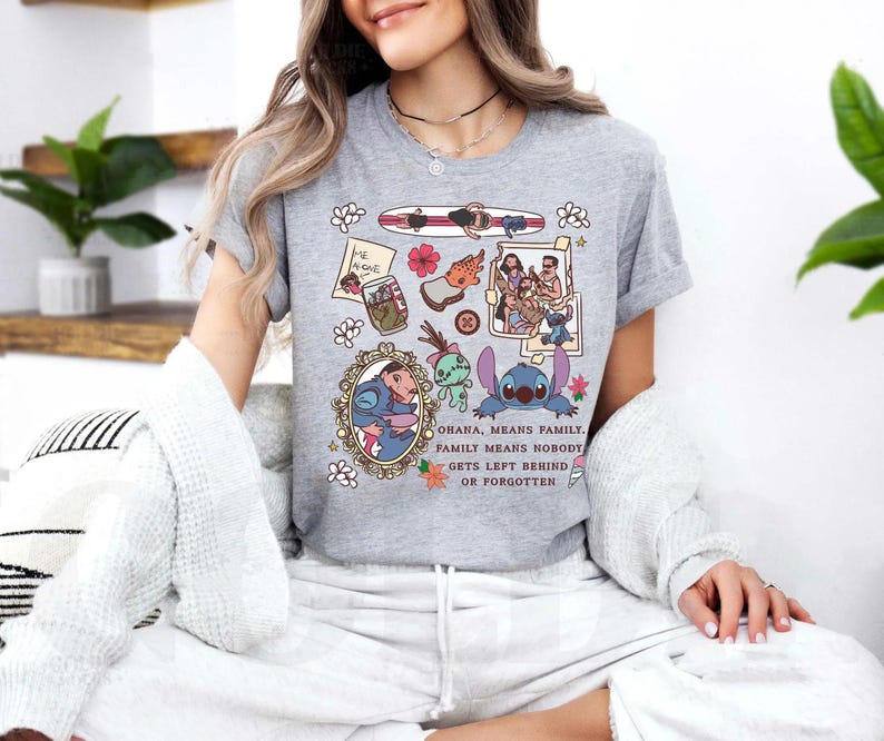Peut inclure: T-shirt gris chin&eacute; avec un motif graphique color&eacute;. Le motif comprend un personnage de dessin anim&eacute; et d'autres images connexes, avec le texte "Ohana, means family. Family means nobody gets left behind or forgotten."
