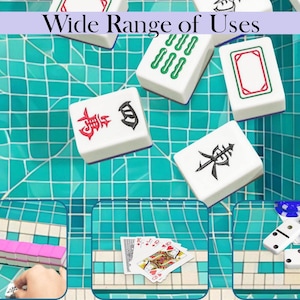 May include: White Mahjong tiles with red, green, and black symbols are displayed on a turquoise tiled surface. The image includes the text "Wide Range of Uses" at the top. Other game pieces, including dominoes and playing cards, are also shown.