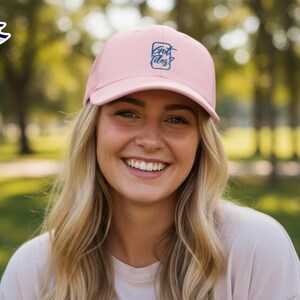 Op de afbeelding: Lichtroze baseballpet met de tekst "Got Vibes?" in donkerblauwe letters. De pet heeft een gebogen klep en is gemaakt van een zachte stof. Deze pet is een modieus accessoire voor dagelijks gebruik.