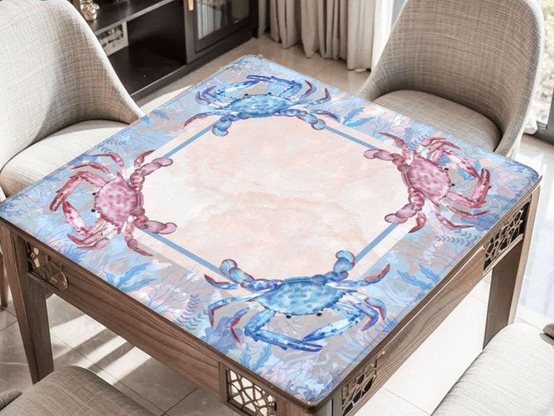 Puede incluir: Mesa cuadrada de madera con dise&ntilde;o de cangrejos. La mesa presenta un patr&oacute;n de cangrejos azul claro y rosa sobre un fondo rosa claro y azul. La mesa est&aacute; rodeada de dos sillas.