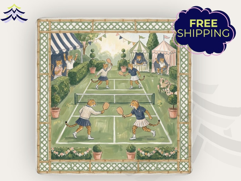 May include: Square decorative art print featuring a tennis match scene with cheetahs playing on a green court. The print has a bamboo-style border and includes tents, spectators, and potted plants. The color palette is soft, with greens, blues, and creams.