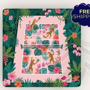 May include: A pink pickleball court design featuring cheetahs playing pickleball, surrounded by tropical flowers and foliage. The design includes a net and the text "FREE SHIPPING" in a dark blue bubble.