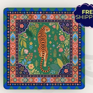 May include: A square coaster featuring a central orange and black tiger surrounded by colorful flowers and foliage on a green background. The design is framed by a decorative border with geometric patterns in shades of blue, orange, and pink.