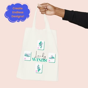 May include: Cream-colored tote bag featuring four Mahjong tiles with teal and pink accents. The text "Lucky Winds" is centered below the tiles. A blue cloud-shaped graphic with the text "Create Endless Designs!" is in the upper left corner.