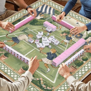 May include: A group of people playing mahjong on a decorative table. The table features a green tennis court design with cheetah illustrations. Pink and white tiles are arranged around the table. The players are holding pink and white tiles.