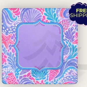 May include: A square, patterned item with a vibrant design featuring pink, blue, and purple seashell and floral motifs. A central, light purple, framed area is surrounded by text. The words "PLAY RIGHT" and "WALK LEFT" are visible.