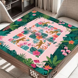May include: A square wooden table with a pink and green floral design. The table's surface features a tennis court design with cheetahs playing. The edges are adorned with tropical flowers and foliage.