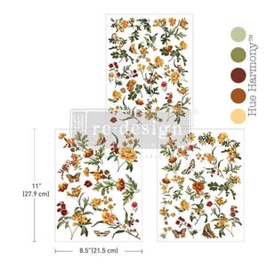 Könnte beinhalten: Ein Set aus drei dekorativen Transferbögen mit botanischen Illustrationen von gelben, orangen und roten Blumen mit grünen Blättern und Schmetterlingen. Die Bögen messen 27,9 cm mal 21,5 cm. Der Text "re-design" und "Hue Harmony" ist sichtbar.