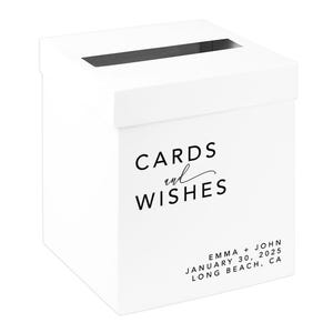May include: A white card box with a slot on top for cards and wishes. The box has the words "CARDS and WISHES" printed in black. The bottom of the box has the names "EMMA + JOHN" and the date "JANUARY 30, 2025" and the city "LONG BEACH, CA" printed in black.