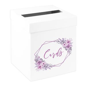 May include: A white card box with a slot on top. The box features a purple floral design with the word "Cards" in a script font within a geometric frame. Ideal for weddings or events.