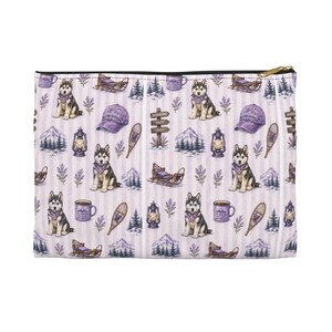 Op de afbeelding: Een rechthoekig tasje met ritssluiting en een herhalend patroon op een lichtpaarse gestreepte achtergrond. De print bevat illustraties van huskyhonden met paarse bandana's, baseballpetten, lantaarns, sledes, sneeuwschoenen en mokken.