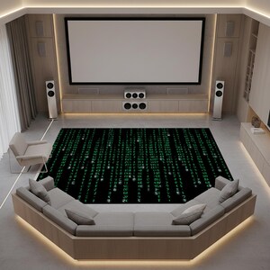 Puede incluir: Una moderna configuración de cine en casa con una gran pantalla de proyección, altavoces y un elegante sofá seccional. Una alfombra negra con un diseño de código de matriz verde cubre el suelo, añadiendo una estética inspirada en la tecnología.