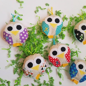 May include: Six colorful handmade felt owl toys with different patterns and colors. The owls have large eyes, beaks, and feet. They are perfect for children's play or as decorations.