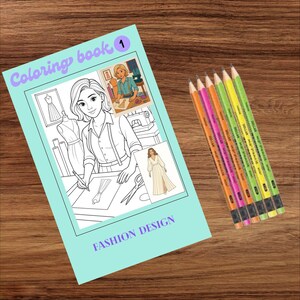 Może przedstawiać: Książka do kolorowania Fashion Design z jasnoniebieską okładką, przedstawiająca czarno-białą ilustrację kobiety szkicującej projekty. Sześć kolorowych ołówków ułożonych obok książki na drewnianej powierzchni.
