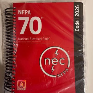May include: A red spiral-bound book titled "NFPA 70 National Electrical Code" with the "nec" logo and "Code 2026" on the side. The book is in a clear plastic wrap.